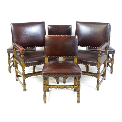 1684 - A set of six early 20thC oak and leather dining chairs with studwork detailing and raised on block a... 