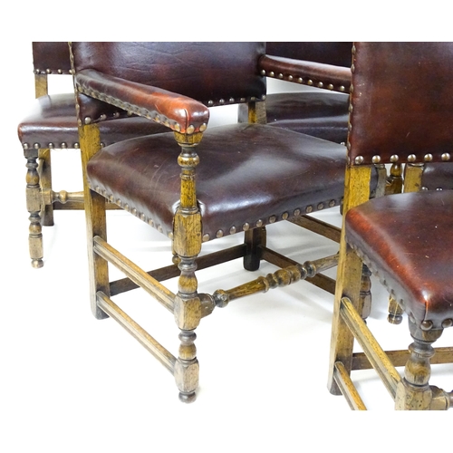 1684 - A set of six early 20thC oak and leather dining chairs with studwork detailing and raised on block a... 