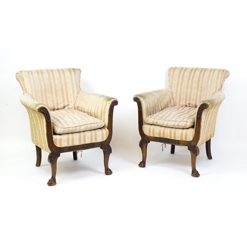 1687 - A pair of Edwardian armchairs with scrolled arms raised on carved cabriole legs terminating in ball ... 