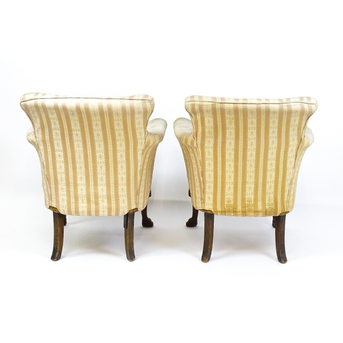 1687 - A pair of Edwardian armchairs with scrolled arms raised on carved cabriole legs terminating in ball ... 