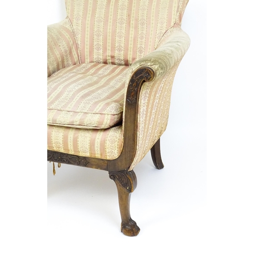 1687 - A pair of Edwardian armchairs with scrolled arms raised on carved cabriole legs terminating in ball ... 