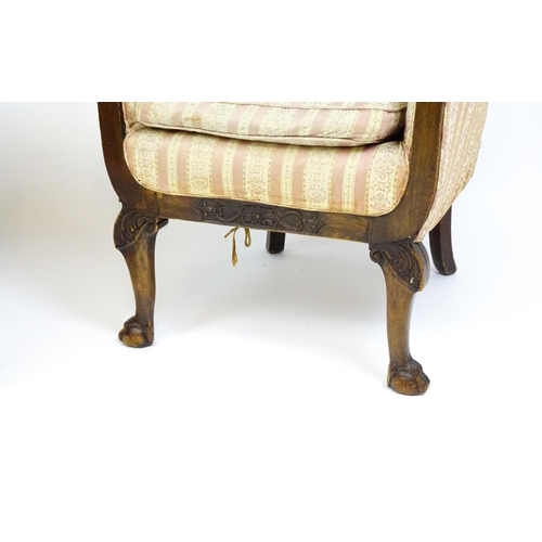 1687 - A pair of Edwardian armchairs with scrolled arms raised on carved cabriole legs terminating in ball ... 