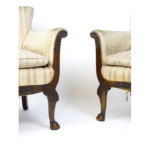 1687 - A pair of Edwardian armchairs with scrolled arms raised on carved cabriole legs terminating in ball ... 