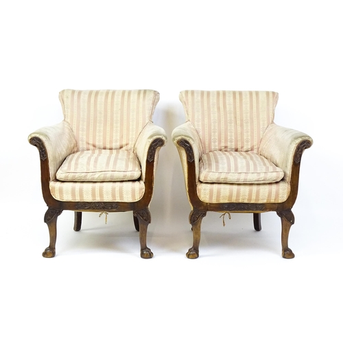 1687 - A pair of Edwardian armchairs with scrolled arms raised on carved cabriole legs terminating in ball ... 