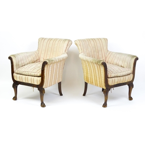 1687 - A pair of Edwardian armchairs with scrolled arms raised on carved cabriole legs terminating in ball ... 