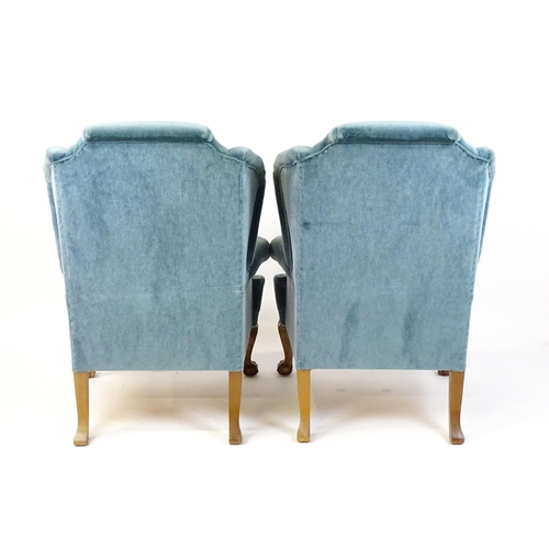 1691 - A pair of early 20thC wingback armchairs with scrolled arms and raised on acanthus carved cabriole f... 