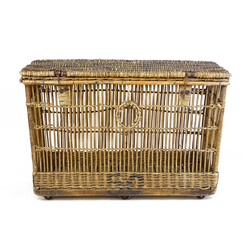 1703 - An early 20thC wicker factory trolley with a hinged lid and raised on six castors. 51