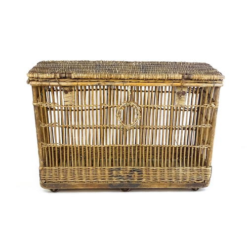 1703 - An early 20thC wicker factory trolley with a hinged lid and raised on six castors. 51