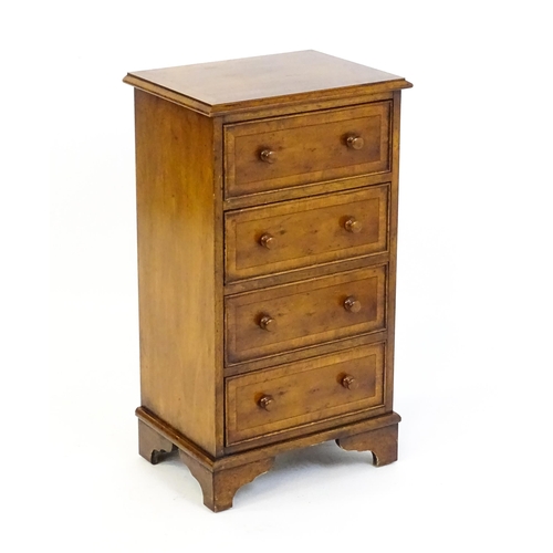 1717 - A late 20thC yew wood bedside cabinet with four short crossbanded drawers with turned wooden handles... 