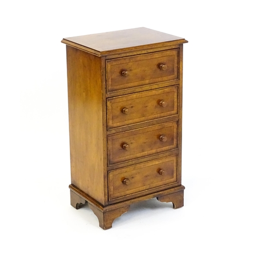 1717 - A late 20thC yew wood bedside cabinet with four short crossbanded drawers with turned wooden handles... 