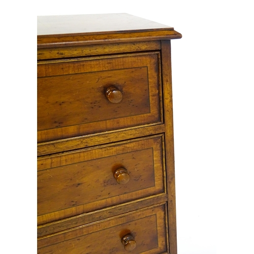 1717 - A late 20thC yew wood bedside cabinet with four short crossbanded drawers with turned wooden handles... 