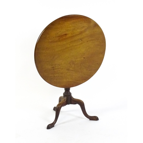 1737 - A Georgian mahogany tripod table with a circular tilt top above a turned pedestal and three cabriole... 