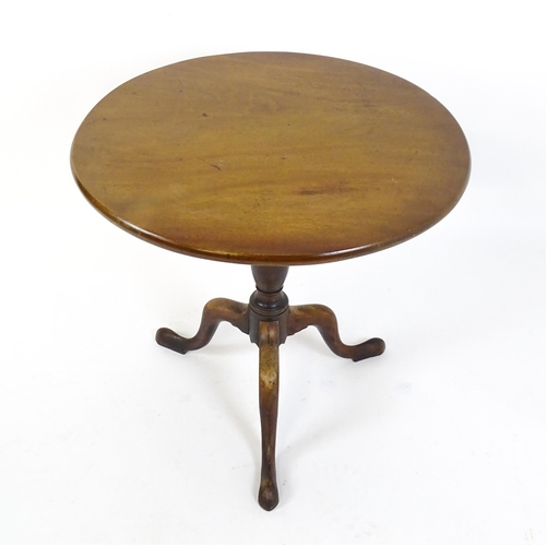 1737 - A Georgian mahogany tripod table with a circular tilt top above a turned pedestal and three cabriole... 