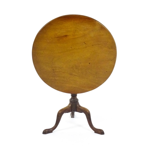 1737 - A Georgian mahogany tripod table with a circular tilt top above a turned pedestal and three cabriole... 