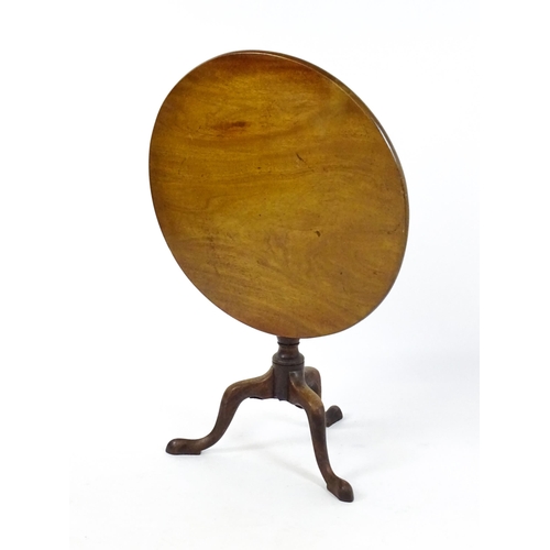 1737 - A Georgian mahogany tripod table with a circular tilt top above a turned pedestal and three cabriole... 