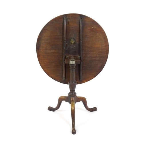 1737 - A Georgian mahogany tripod table with a circular tilt top above a turned pedestal and three cabriole... 