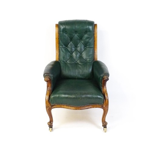 1692 - A Victorian green leather armchair with a deep buttoned backrest, scrolled arms and a moulded frame,... 