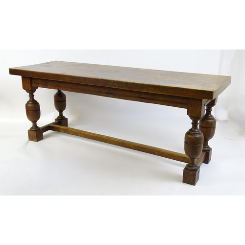 1617 - A late 19thC oak refectory table with a rectangular top above four cup and cover legs united by a H-... 