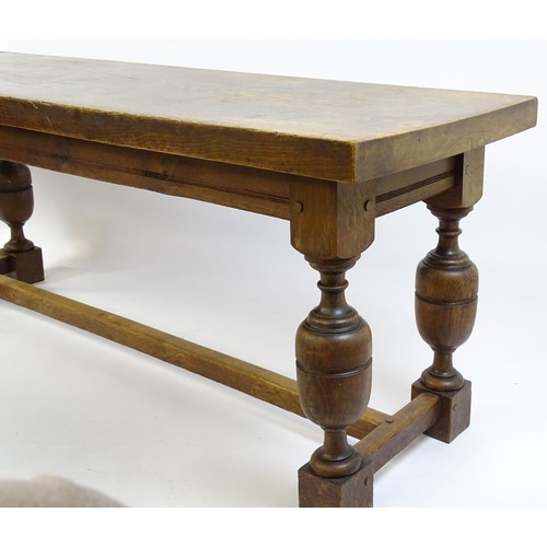 1617 - A late 19thC oak refectory table with a rectangular top above four cup and cover legs united by a H-... 