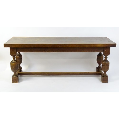 1617 - A late 19thC oak refectory table with a rectangular top above four cup and cover legs united by a H-... 