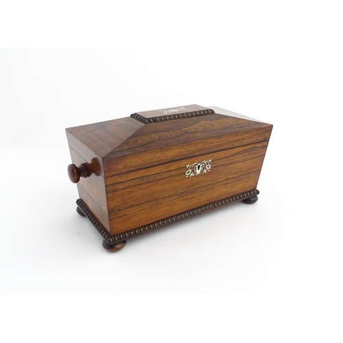 1094 - A 19thC rosewood tea caddy of sarcophagus form with inlaid foliate and foliate mother of pearl detai... 