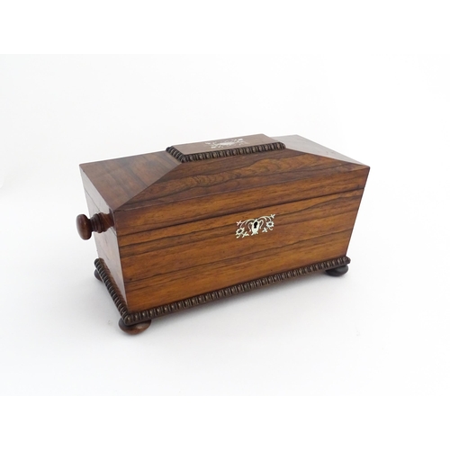 1094 - A 19thC rosewood tea caddy of sarcophagus form with inlaid foliate and foliate mother of pearl detai... 