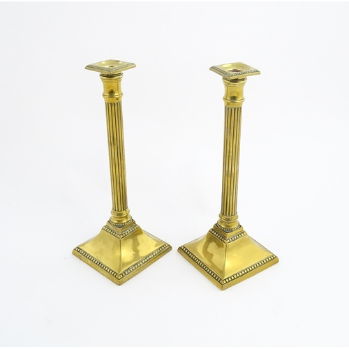 1096 - A pair of 19thC brass candlesticks of column form with squared bases. Approx. 11 1/4