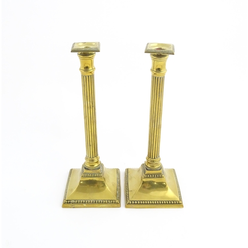 1096 - A pair of 19thC brass candlesticks of column form with squared bases. Approx. 11 1/4