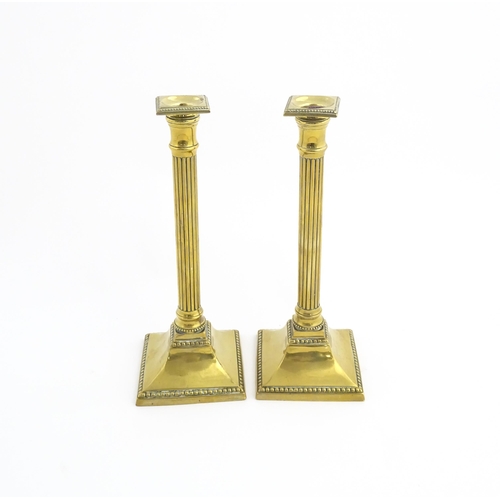 1096 - A pair of 19thC brass candlesticks of column form with squared bases. Approx. 11 1/4