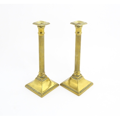 1096 - A pair of 19thC brass candlesticks of column form with squared bases. Approx. 11 1/4