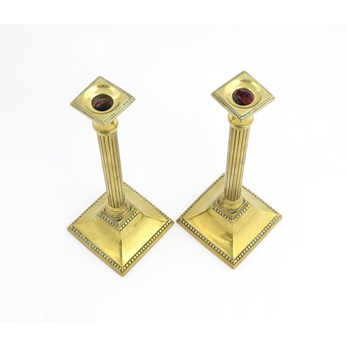 1096 - A pair of 19thC brass candlesticks of column form with squared bases. Approx. 11 1/4