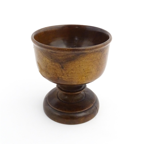 1119 - Treen : A 19thC treen pedestal master salt of squat goblet form with a bladed knopped column on a ci... 