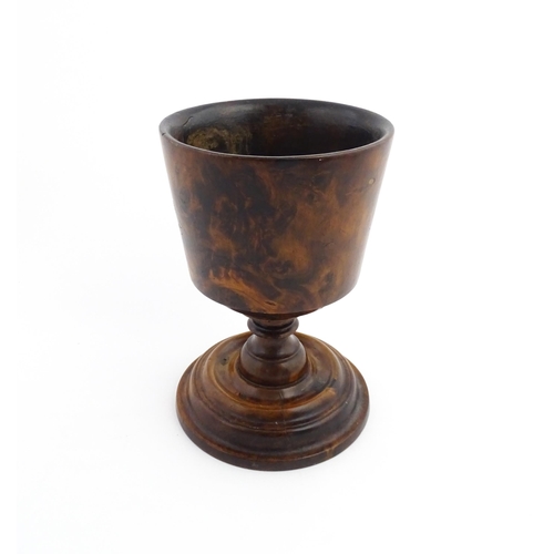 1122 - Treen : An 18thC wooden loving cup with bladed knopped column. Approx. 8 1/2