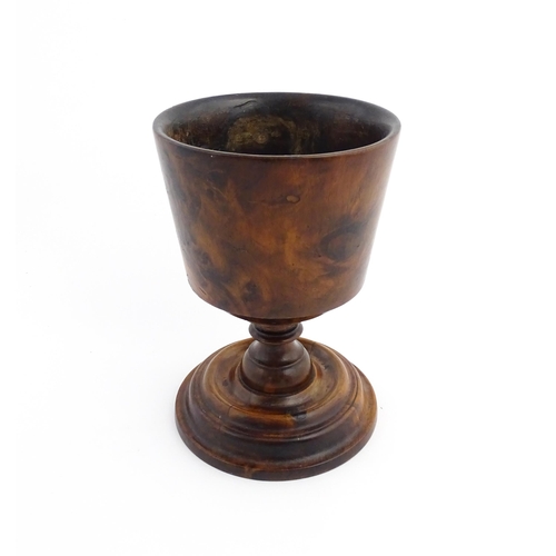 1122 - Treen : An 18thC wooden loving cup with bladed knopped column. Approx. 8 1/2