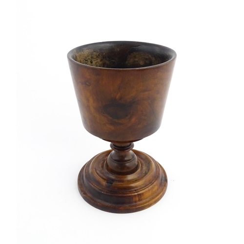 1122 - Treen : An 18thC wooden loving cup with bladed knopped column. Approx. 8 1/2