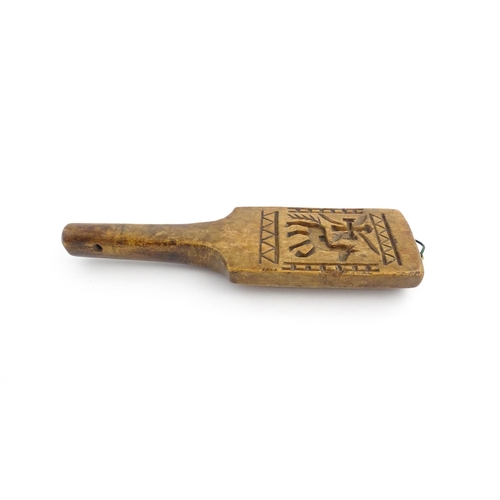 1131 - Treen : A 19thC carved wooden gingerbread biscuit mould of paddle form with horse and cross decorati... 