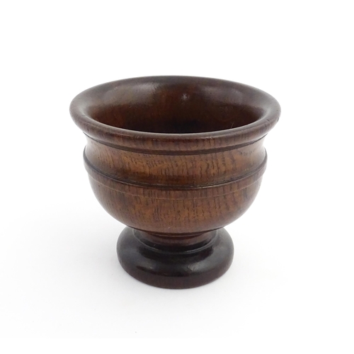 1134 - Treen : An 18th/19thC oak pedestal master salt with banded detail. Approx. 4 1/4