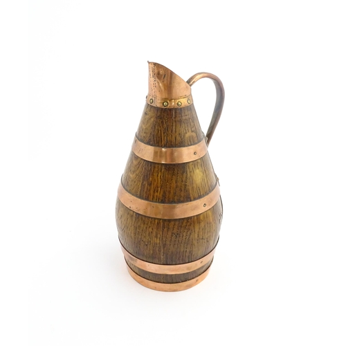 1141 - An early 20thC coopered oak and copper cider jug / flagon. Approx. 10 1/2