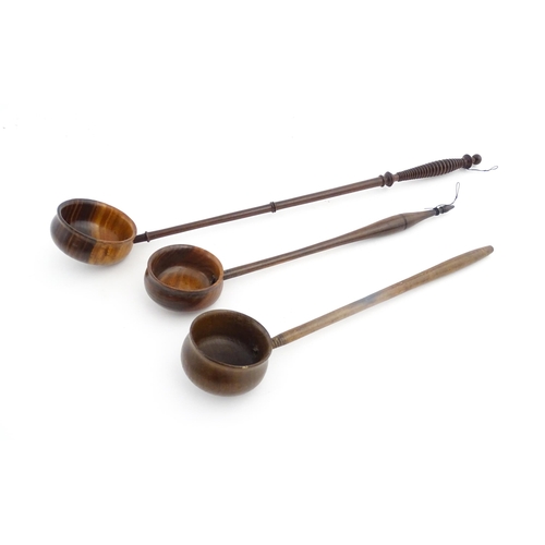 1142 - Treen : Three 18th / 19thC wooden cordial spoons. Largest approx. 17 1/2