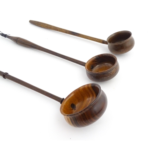 1142 - Treen : Three 18th / 19thC wooden cordial spoons. Largest approx. 17 1/2