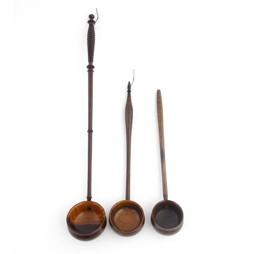 1142 - Treen : Three 18th / 19thC wooden cordial spoons. Largest approx. 17 1/2