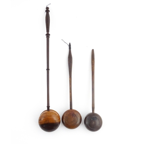 1142 - Treen : Three 18th / 19thC wooden cordial spoons. Largest approx. 17 1/2