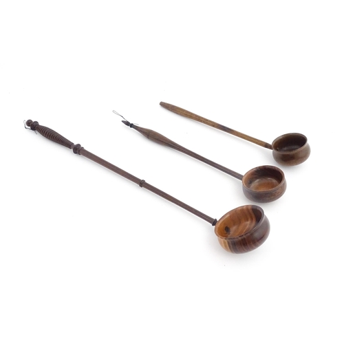 1142 - Treen : Three 18th / 19thC wooden cordial spoons. Largest approx. 17 1/2