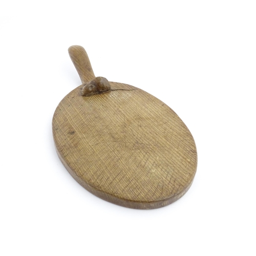 1154 - Treen : An early to mid 20thC Mouseman oak cheese board with carved trademark mouse and adzed detail... 