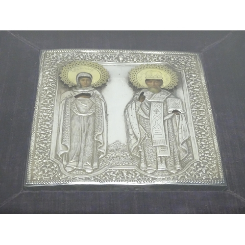 1067 - A 19thC Russian Orthodox icon with embossed silver surround and oil on panel depictions of two saint... 