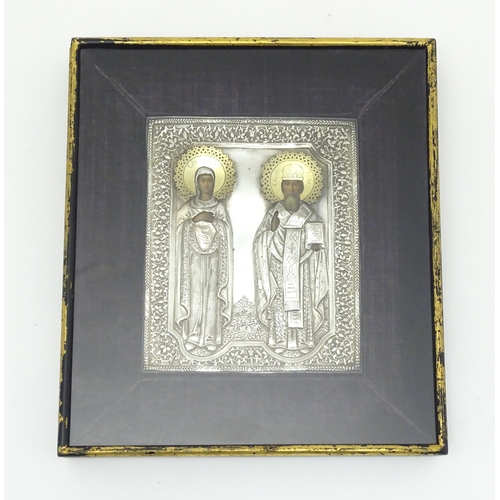 1067 - A 19thC Russian Orthodox icon with embossed silver surround and oil on panel depictions of two saint... 