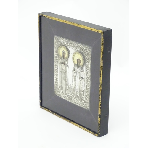 1067 - A 19thC Russian Orthodox icon with embossed silver surround and oil on panel depictions of two saint... 