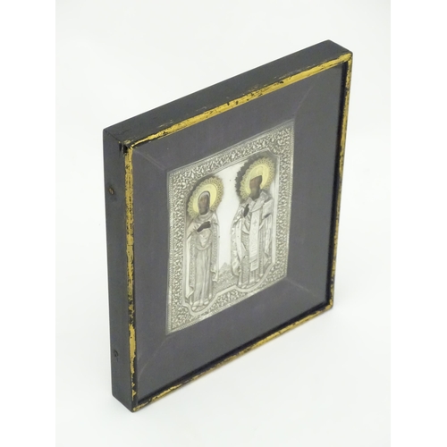 1067 - A 19thC Russian Orthodox icon with embossed silver surround and oil on panel depictions of two saint... 