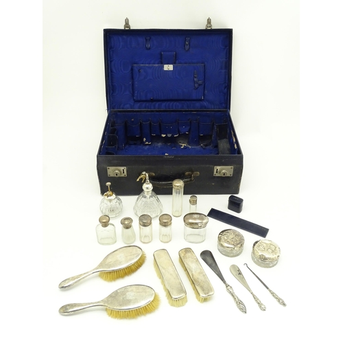 513 - A blue leather vanity case / valise containing a quantity of assorted silver topped bottles, jars, s... 