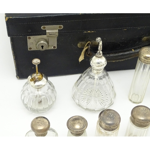 513 - A blue leather vanity case / valise containing a quantity of assorted silver topped bottles, jars, s... 